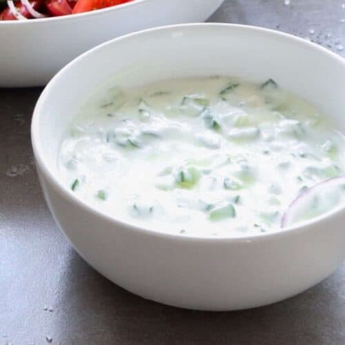 Een close-up van zelfgemaakte tzatziki met komkommer.