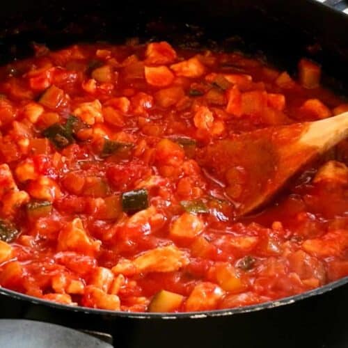 Spaghettisaus met kip en groente in een pan.