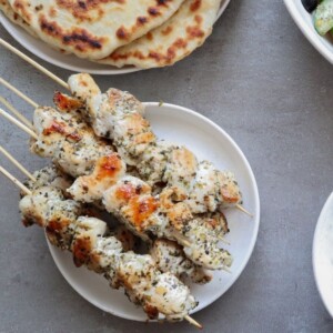 Kip souvlaki op een wit bord.