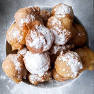 Oliebollen op een schaal met suiker.
