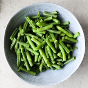 Gekookte sperzieboontjes in een blauwe schaal.