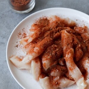 Een close-up van fajitakruiden op kip reepjes.