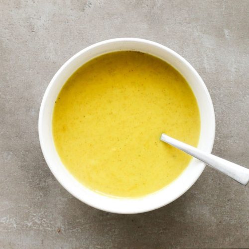 Kerriesaus van bouillon in een witte kom.