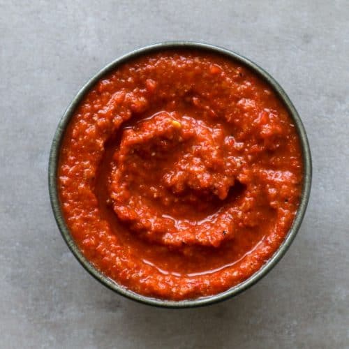 Muhammara in een zwarte schaal op een grijze achtergrond