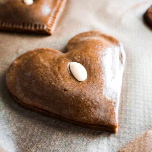 een close up van gevulde speculaas koeken in de vorm van een hart met een amandel