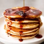een close up van een stapel banaan pannenkoeken met stroop op een bord