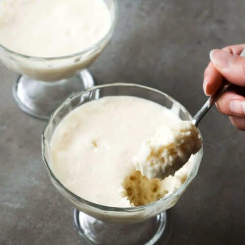 een close up van twee schaaltjes witte chocolademousse en een lepel
