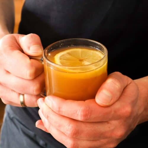 Een man die een hot toddy drankje vasthoudt