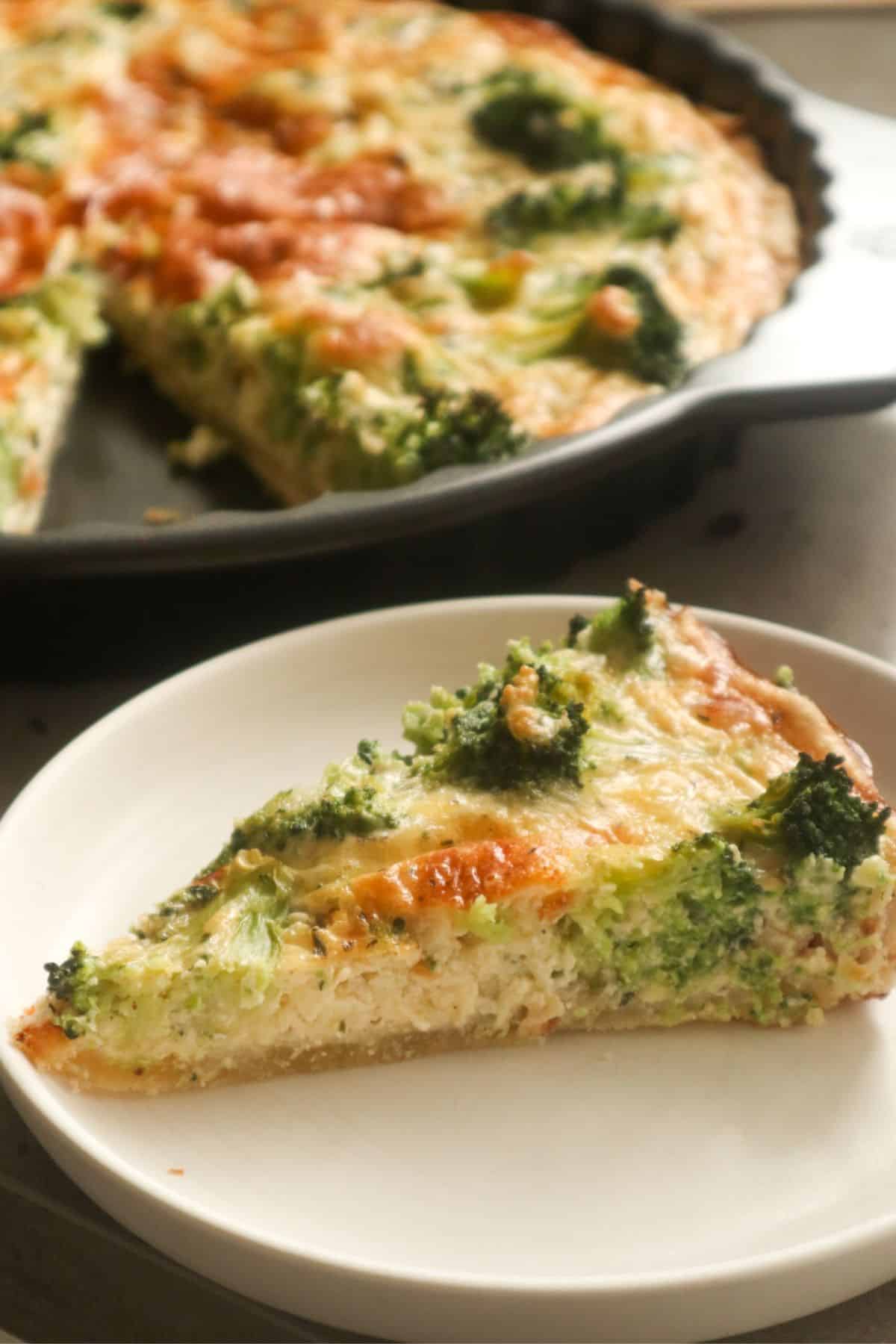 een close up van een punt quiche op een wit schoteltje met een aangesneden broccoli quiche op de achtergrond