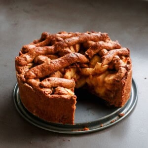 Appeltaart van speculaasdeeg op een grijze achtergrond.